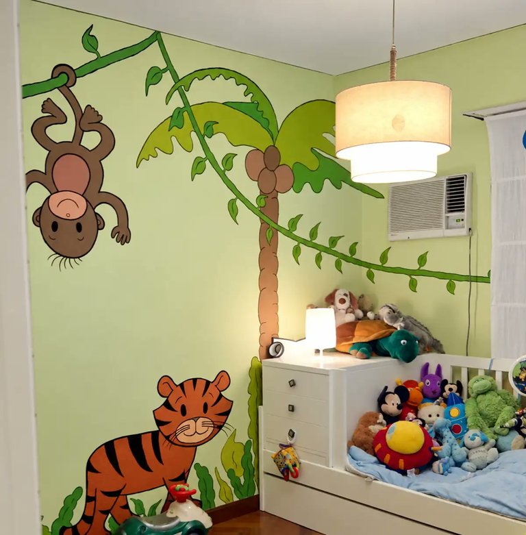 Mural pintado a mano en el dormitorio de los chicos, con animales de la selva